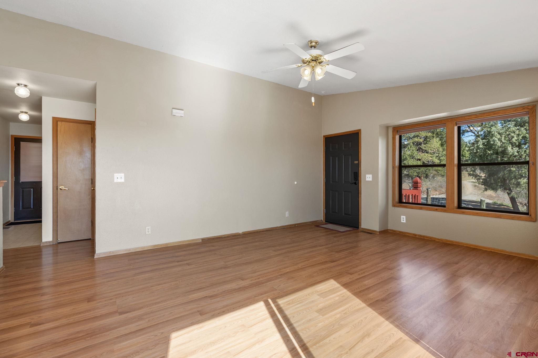 720 Sawmill Road Durango, CO 81303 - Photo 6 of 41 a view of an empty room with window and wooden floor