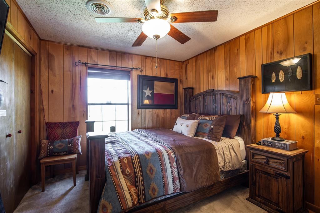 2043 Huddleston Road Sunset, TX 76270 - Photo 16 of 36 a bedroom with a bed and wooden floor
