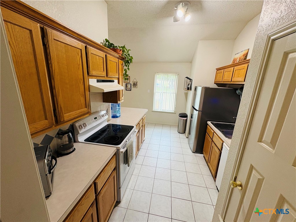 369 County Road 3367 Kempner, TX 76539 - Photo 7 of 18 a kitchen with a refrigerator a stove top oven and a counter top space