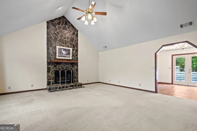 a view of an empty room with a fireplace and a window