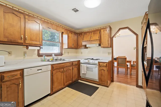 a kitchen with stainless steel appliances granite countertop a sink and cabinets with wooden floor