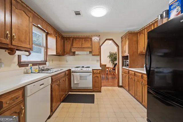 a kitchen with stainless steel appliances granite countertop a stove a sink dishwasher and a refrigerator
