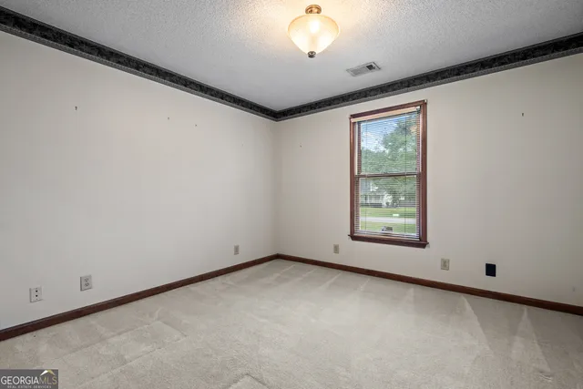 an empty room with a window and a ceiling fan