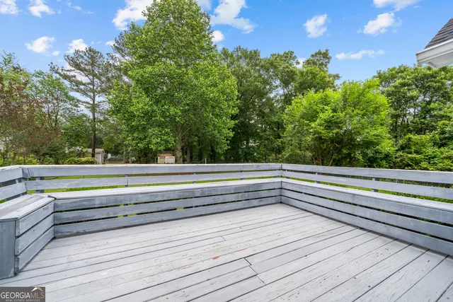 a view of a house next to a big yard and large trees