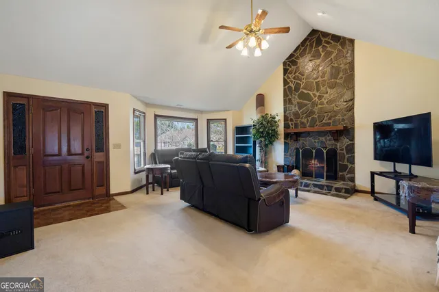 an empty room with chandelier fan and windows