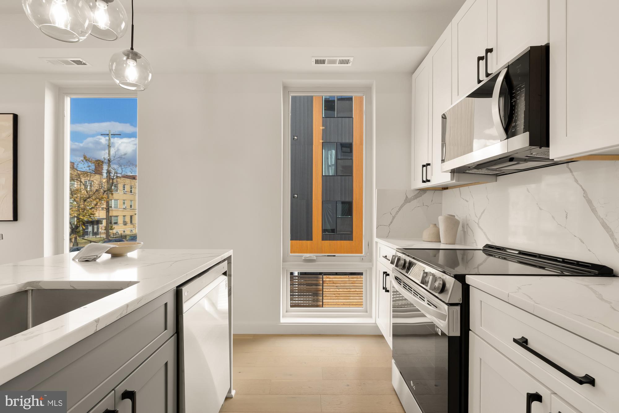 30 Kennedy Street Northwest, Unit 6 Washington, DC 20011 - Photo 15 of 35 a kitchen with stainless steel appliances kitchen island a sink stove and microwave