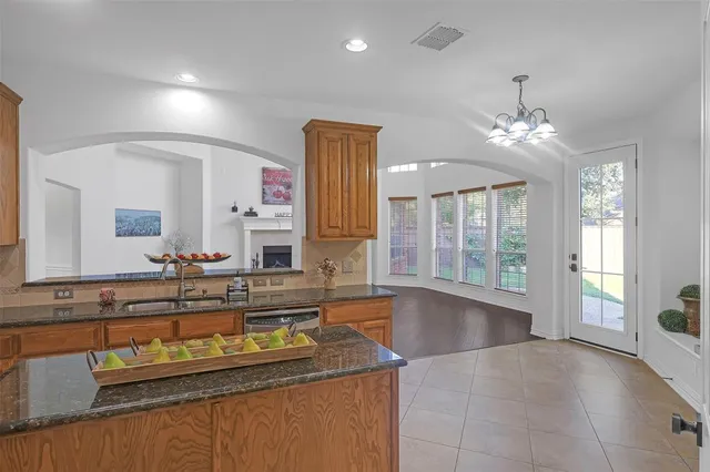 a large kitchen with granite countertop a sink and a stove top oven