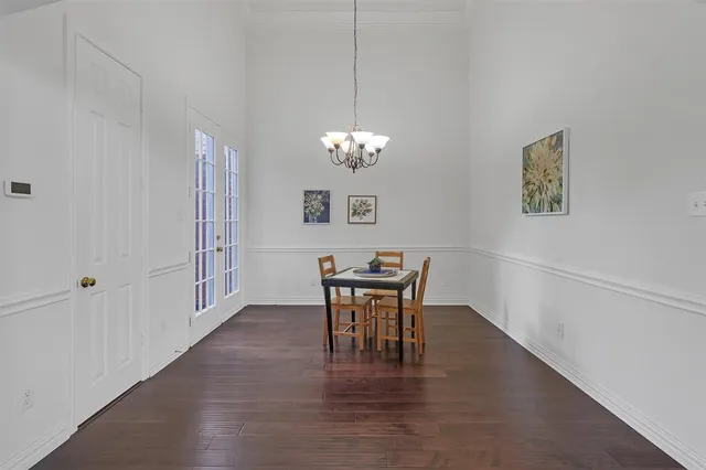 a view of a dining room with furniture a chandelier and wooden floor