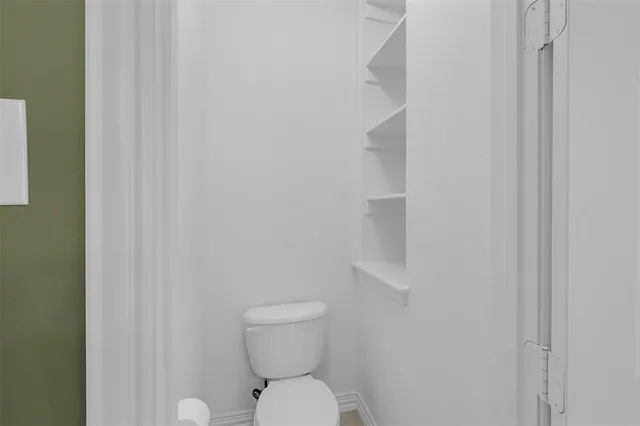 a white toilet sitting next to a shower