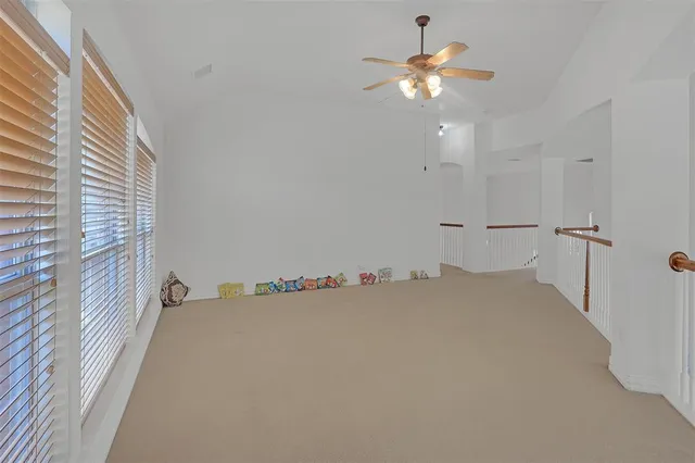 a view of a room with a ceiling fan and a window