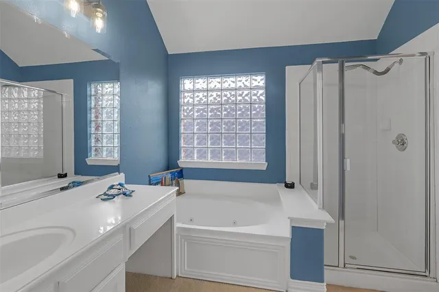 a bathroom with a tub a sink and a window