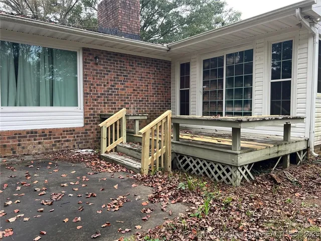 a view of a house with a small yard and wooden floor and fence