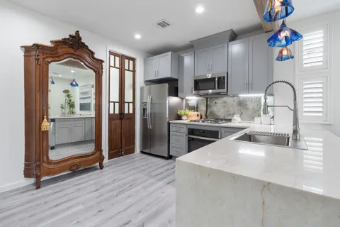 a kitchen with granite countertop a refrigerator and a sink
