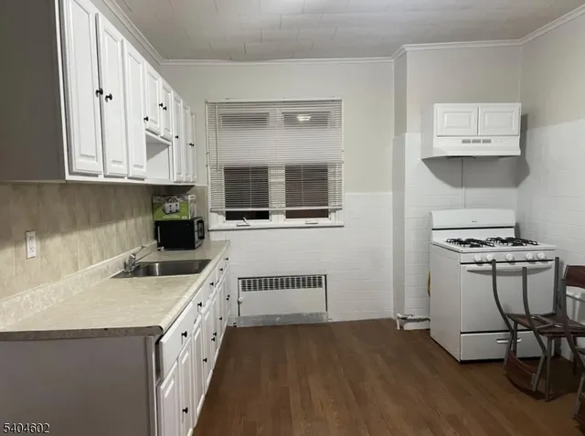 a kitchen with white cabinets and sink