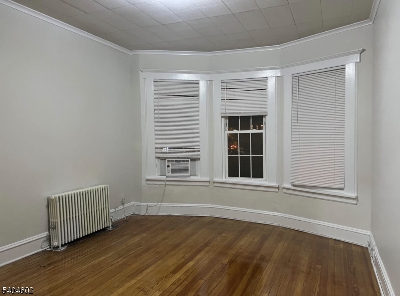 234 Christine Street, Unit 2F Elizabeth, NJ 07202 - Photo 8 of 11 a view of an empty room with wooden floor and a window