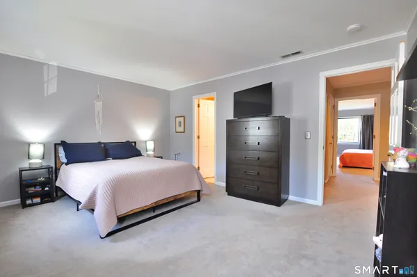 a spacious bedroom with a bed and a television in it
