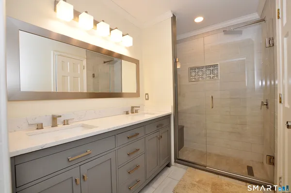a bathroom with a shower sink and mirror