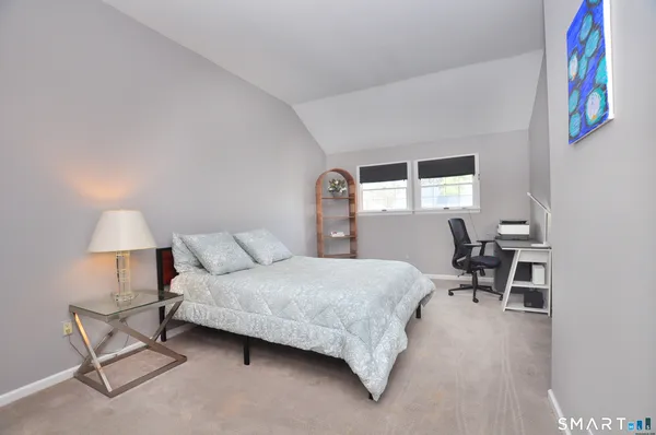 a bedroom with a bed chairs and a window