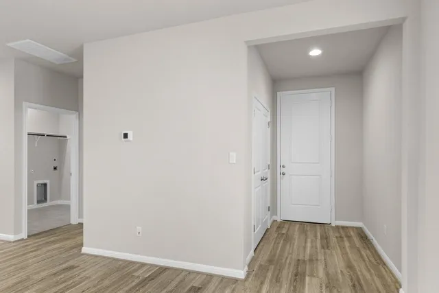an empty room with wooden floor and entrance