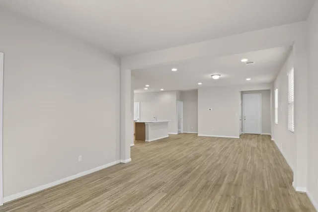 a view of an empty room with wooden floor