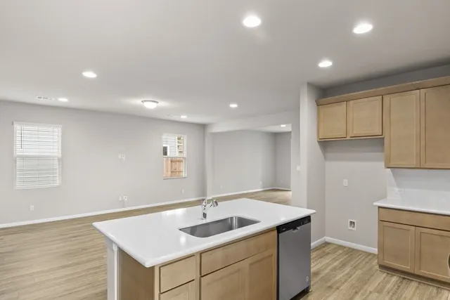 a kitchen with a sink cabinets and wooden floor