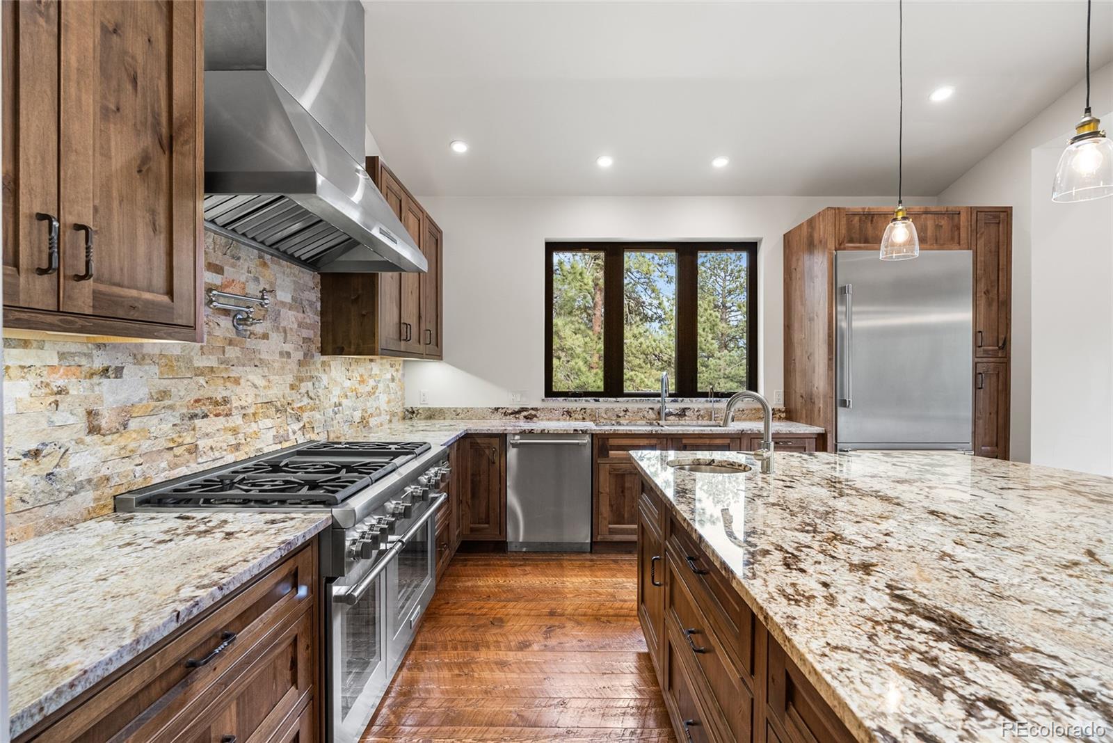 280 Double Tree Road Bailey, CO 80421 - Photo 14 of 43 a kitchen with stainless steel appliances granite countertop sink stove and granite counter top