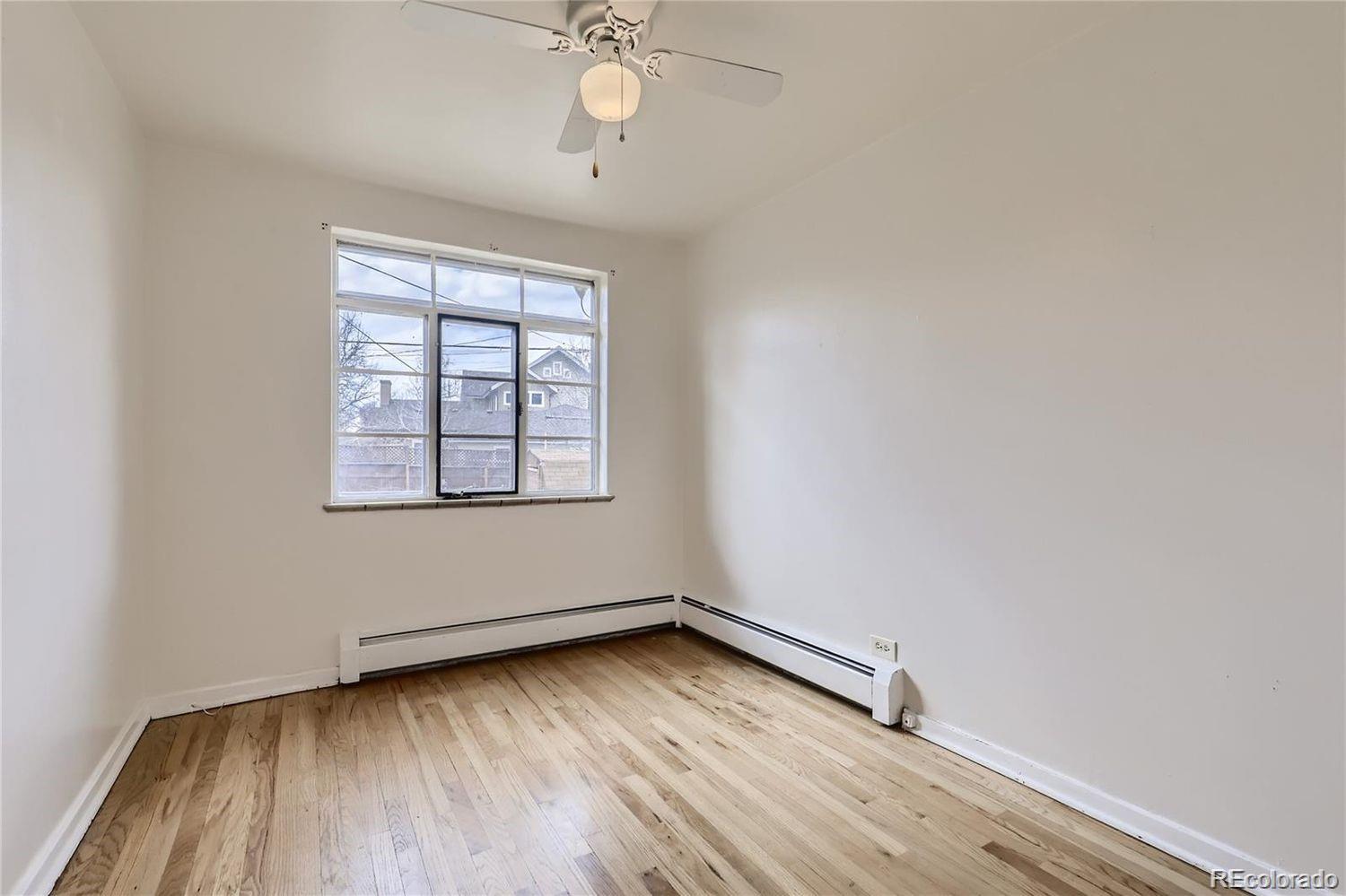411 Quebec Street Denver, CO 80220 - Photo 18 of 31 an empty room with wooden floor chandelier fan and windows