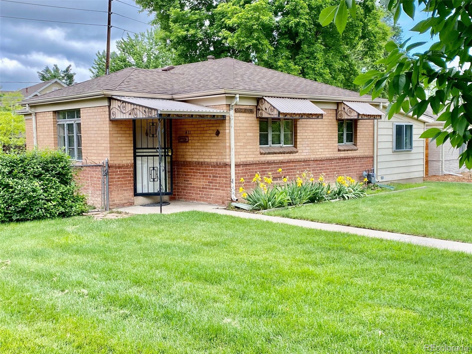 411 Quebec Street Denver, CO 80220 - Photo 2 of 31 a view of a yard in front of a house with plants and large tree