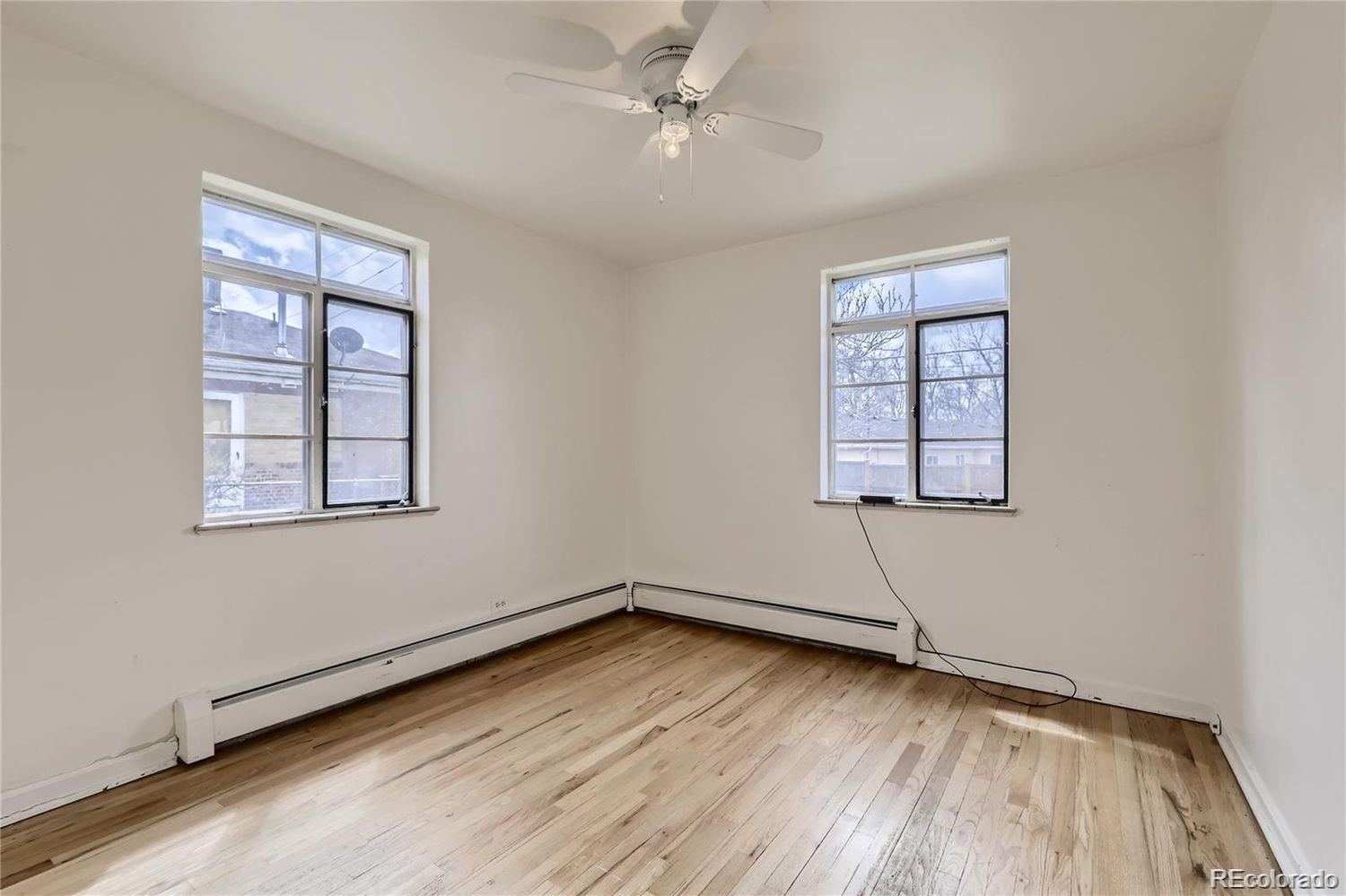 411 Quebec Street Denver, CO 80220 - Photo 5 of 31 an empty room with wooden floor ceiling fan and windows