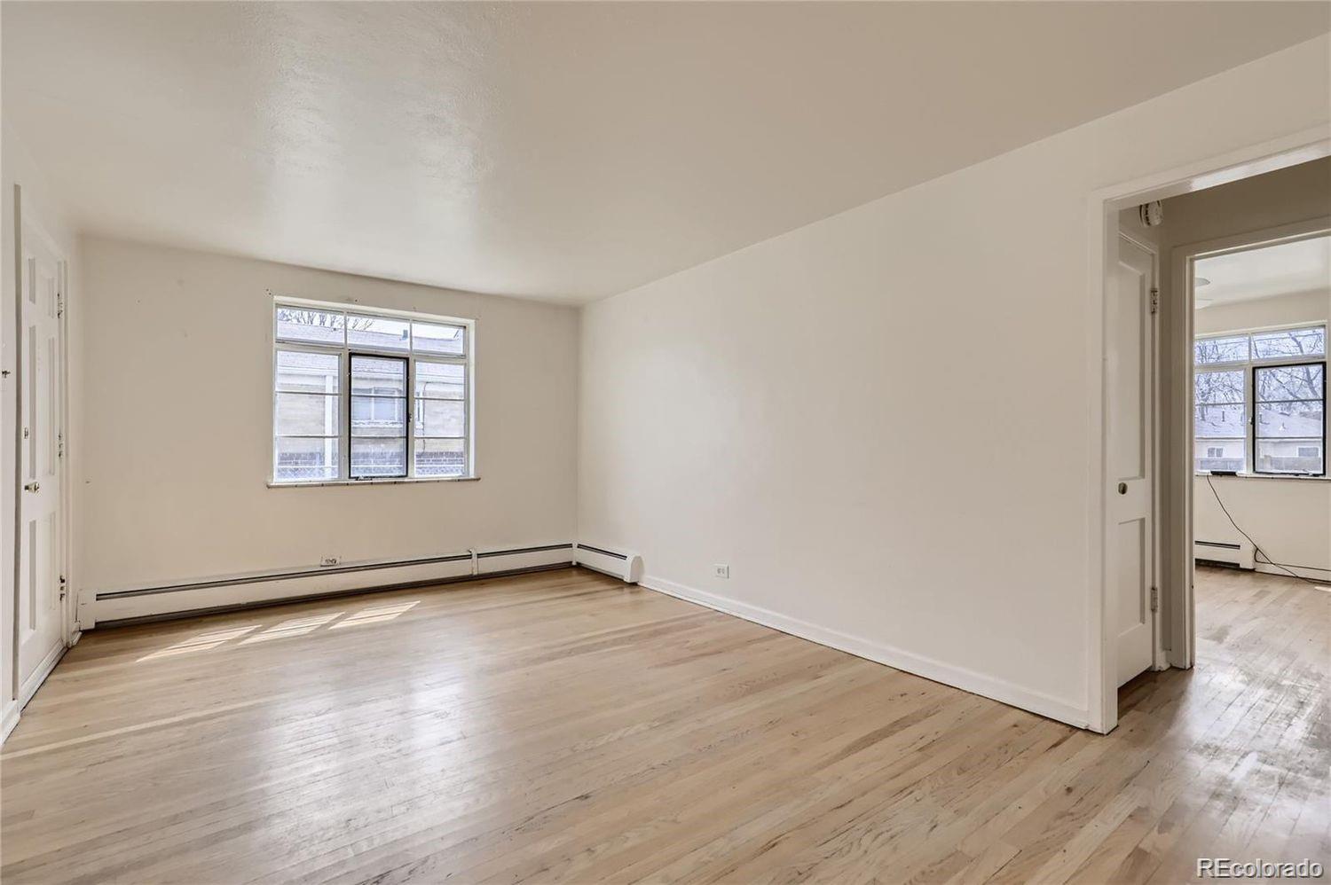 411 Quebec Street Denver, CO 80220 - Photo 6 of 31 an empty room with wooden floor and windows