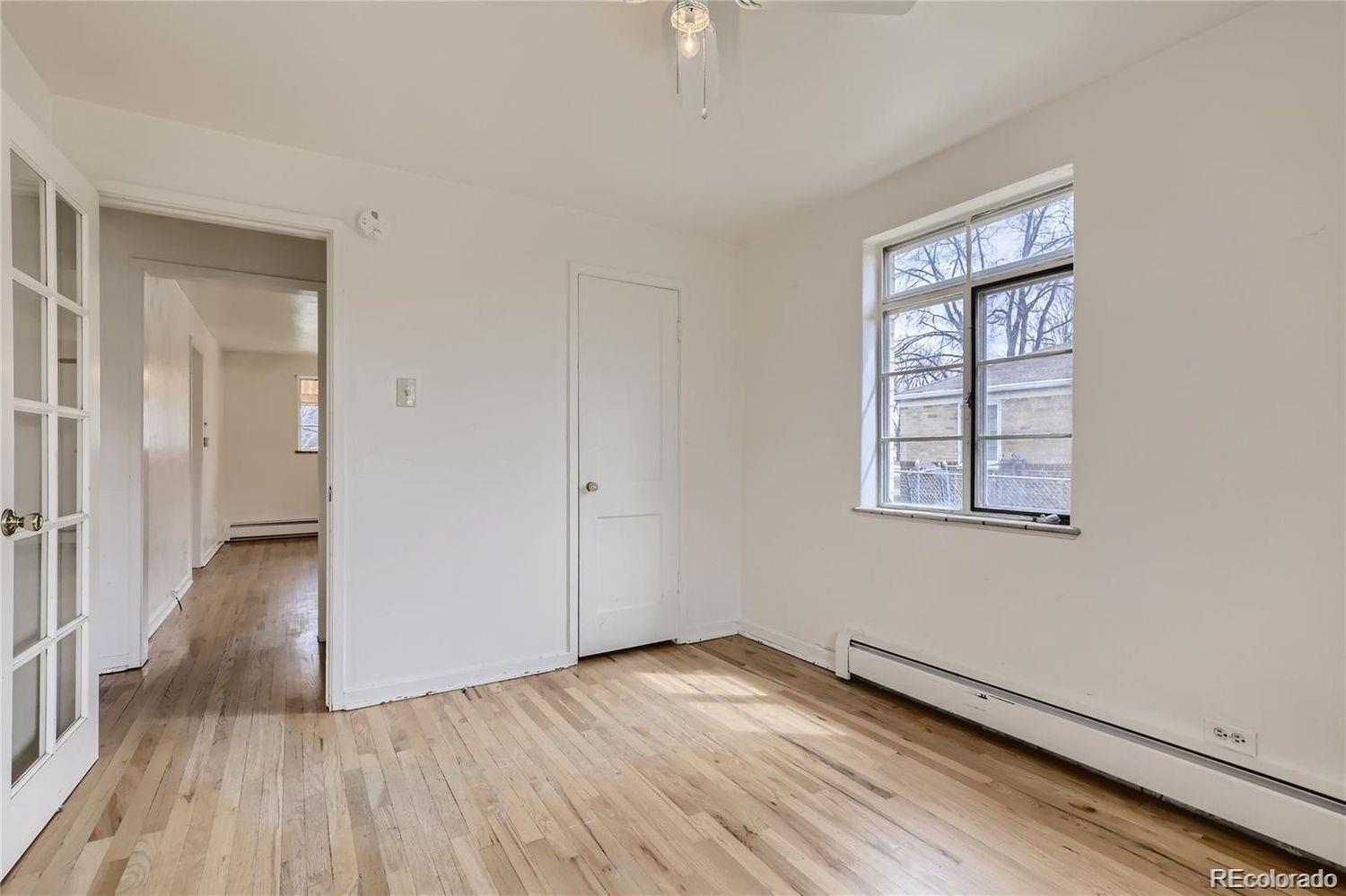 411 Quebec Street Denver, CO 80220 - Photo 7 of 31 an empty room with wooden floor and windows