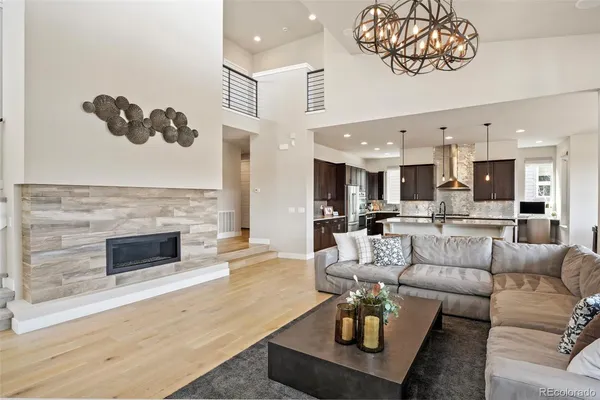 a kitchen with stainless steel appliances granite countertop a stove top oven a sink a dining table and chairs with wooden floor