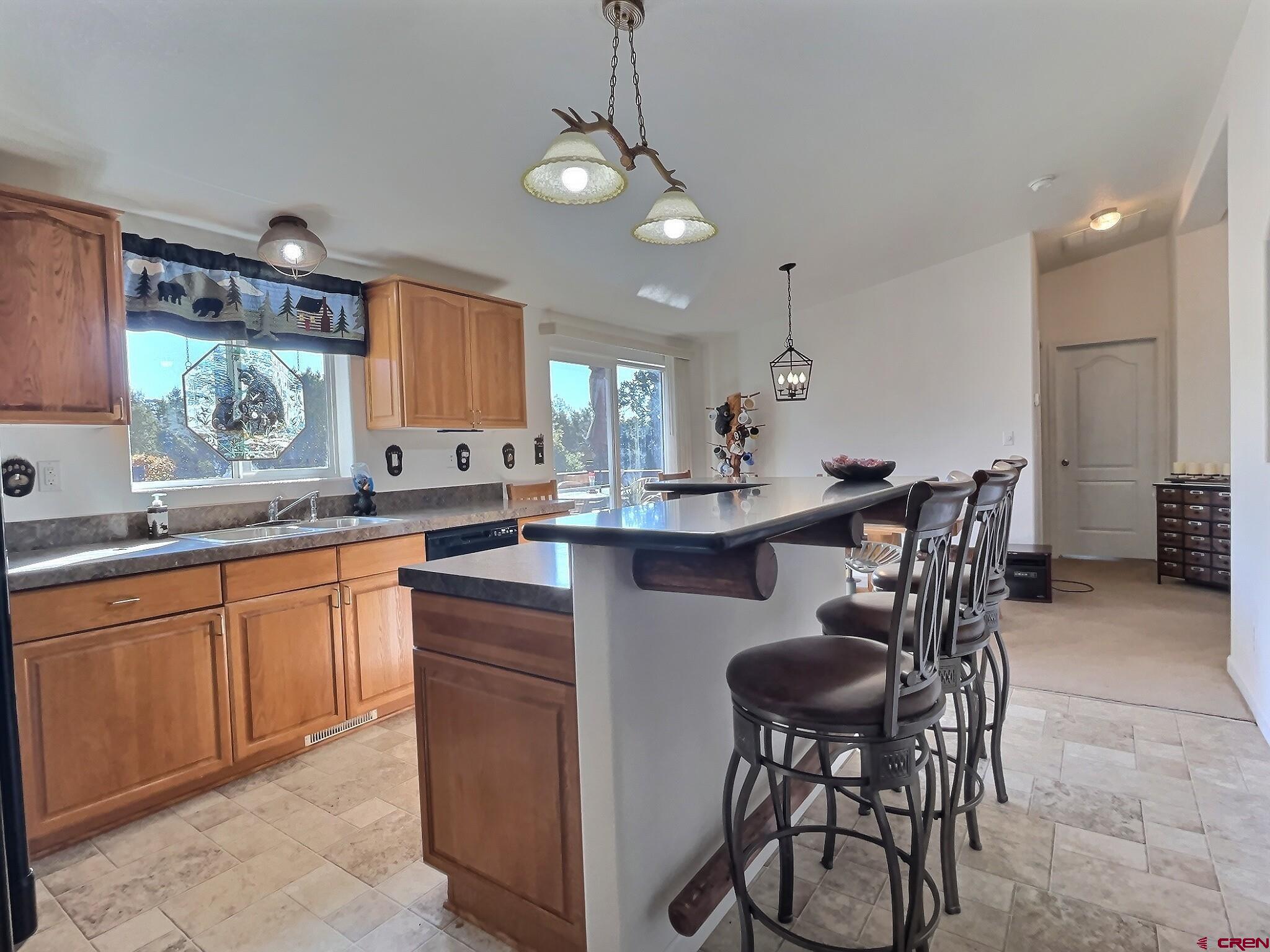 21049 Upland Road Cedaredge, CO 81413 - Photo 11 of 34 a kitchen with kitchen island a dining table and chairs