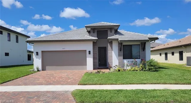 a front view of a house with a yard and garage
