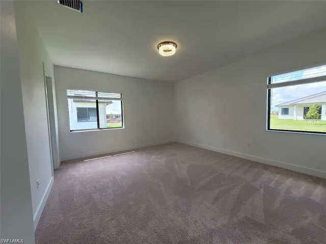 an empty room with windows and closet