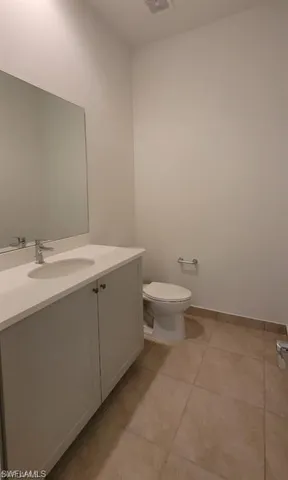 a bathroom with a granite countertop toilet and sink