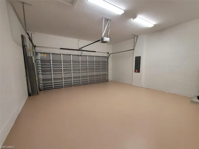 a view of an empty room with staircase and windows