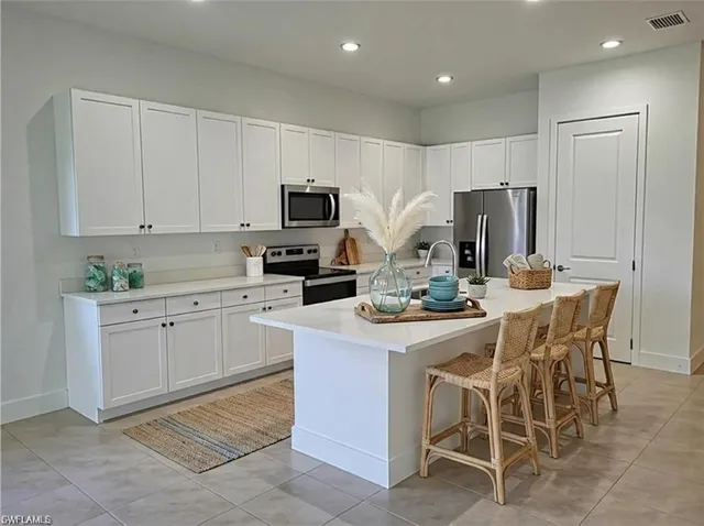 a kitchen with white cabinets and stainless steel appliances