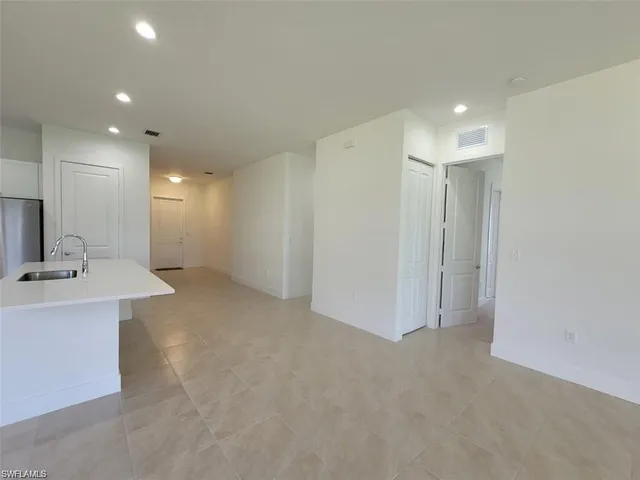 a view of a kitchen with a sink and a refrigerator