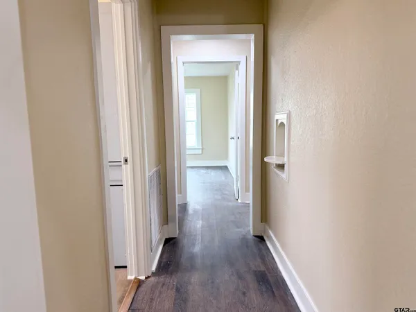 a view of a hallway with wooden floor