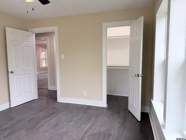 an empty room with wooden floor & closet