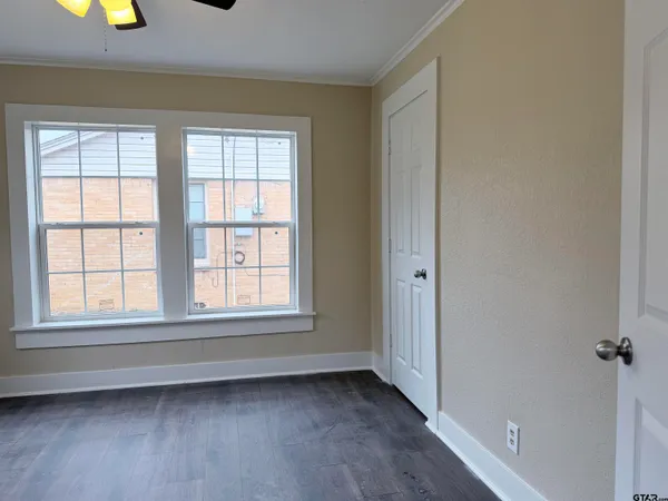 an empty room with windows and closet