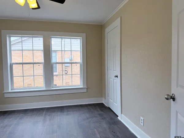 an empty room with windows and closet