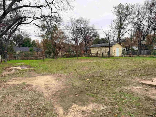 a front view of house with yard and trees around