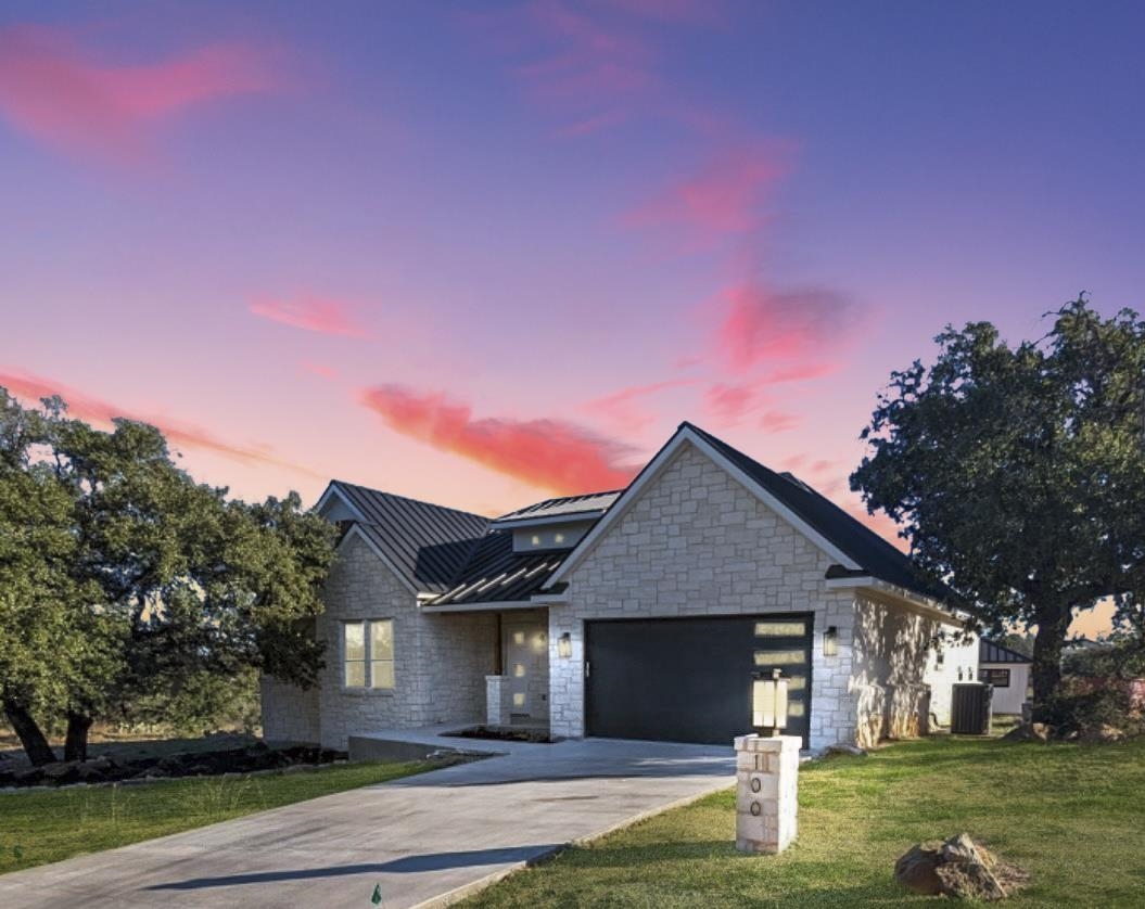 a front view of a house with a yard garage and trees