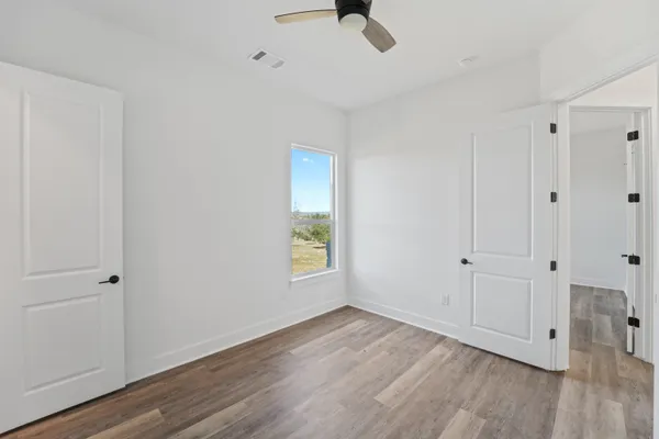 a view of an empty room with wooden floor