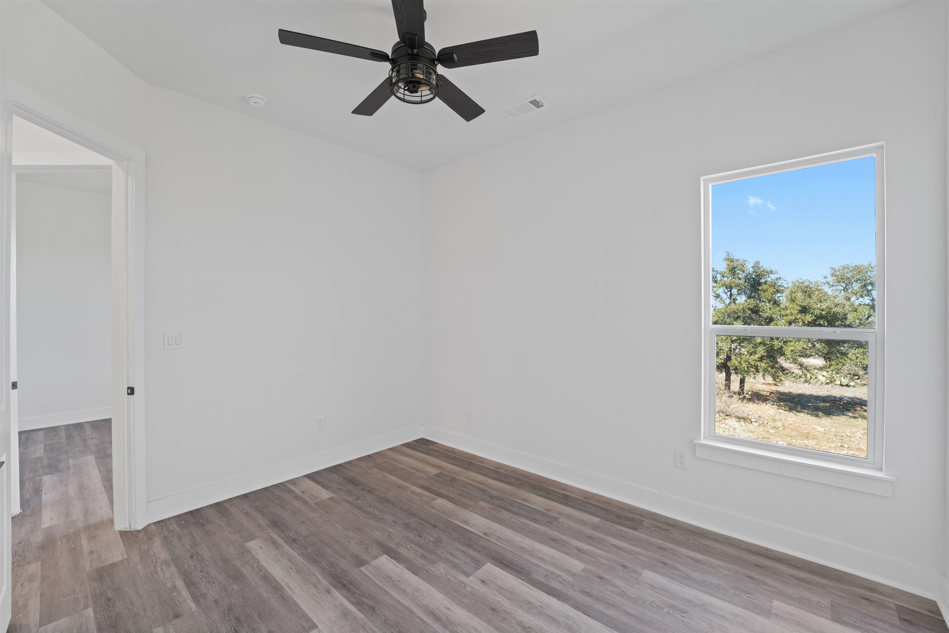 100 Up There Horseshoe Bay, TX 78657 - Photo 23 of 28 an empty room with wooden floor fan and windows