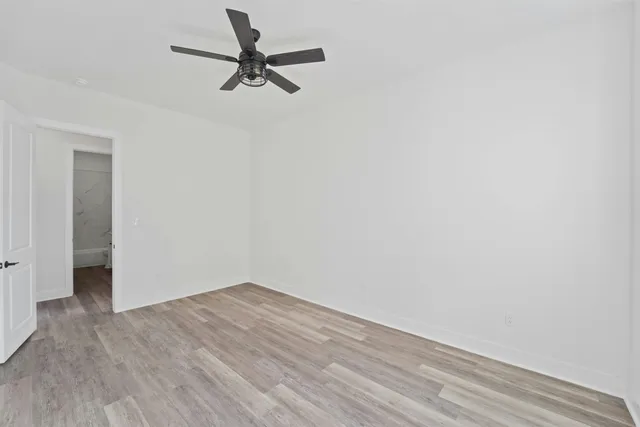 a view of a room with wooden floor and a ceiling fan