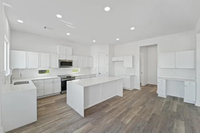 a kitchen with white cabinets and stainless steel appliances
