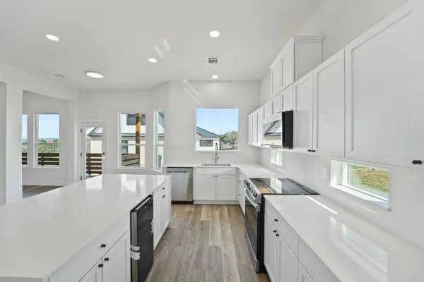 a large kitchen with stainless steel appliances lots of counter space and wooden floor